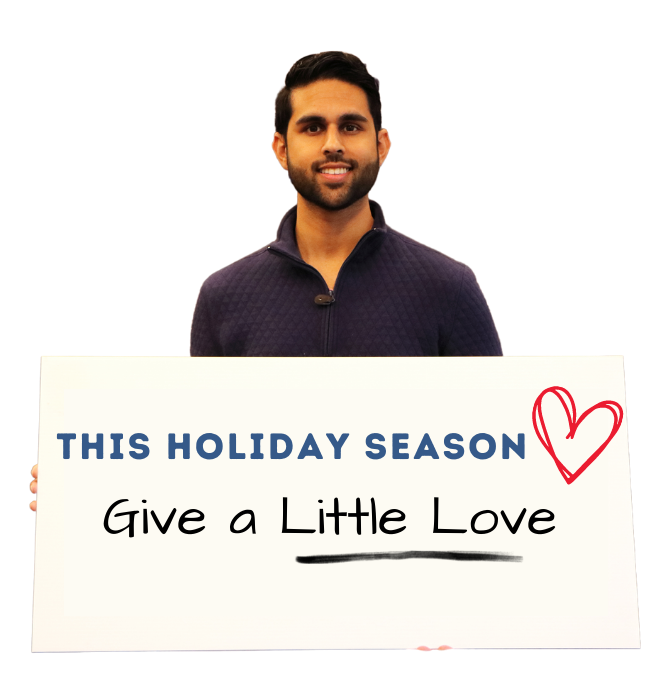 MHA staff member holds sign saying This Giving Tuesday Give a Little Love