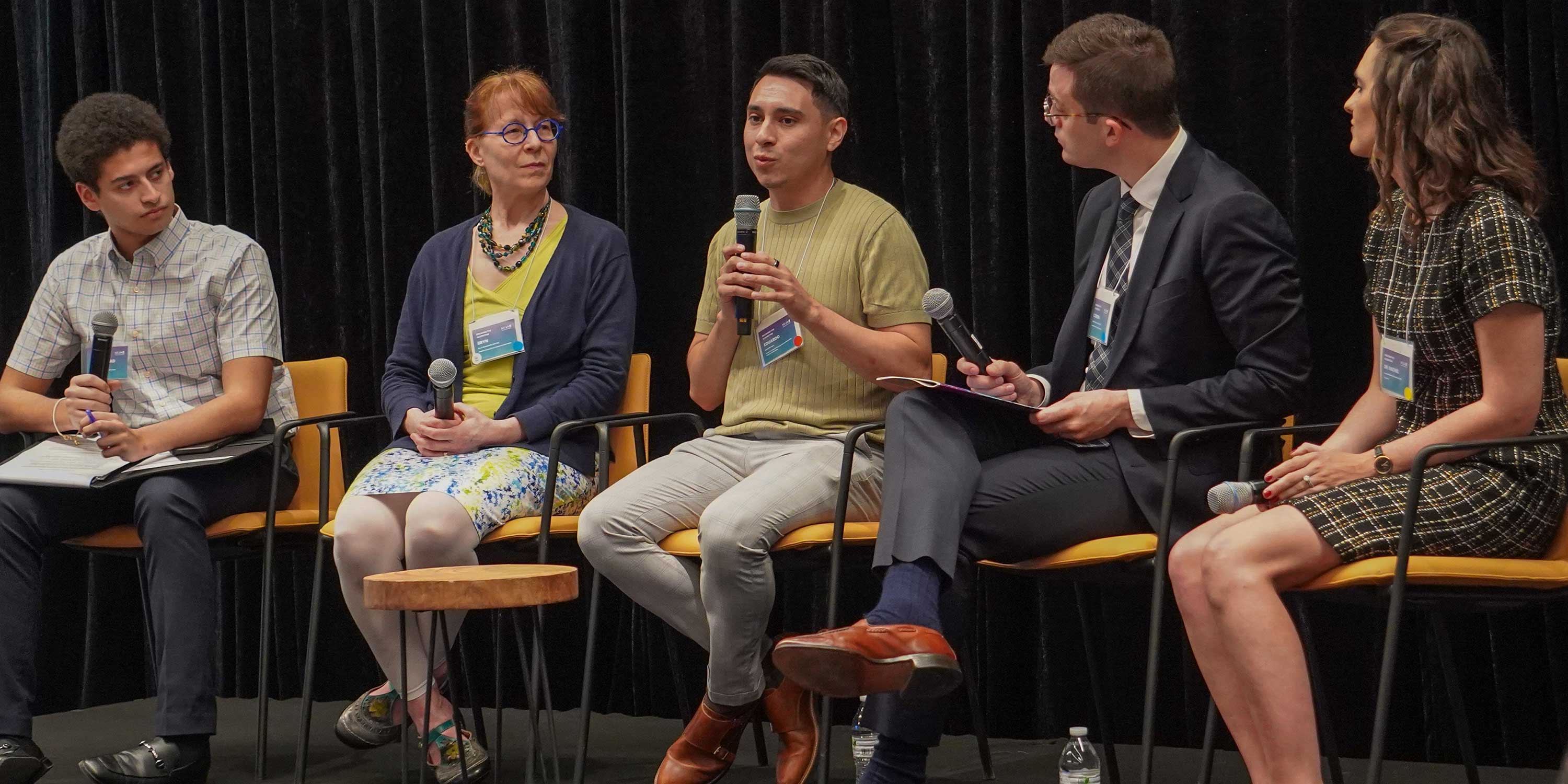 group of panelists talk on stage at Breaking the Algorithm