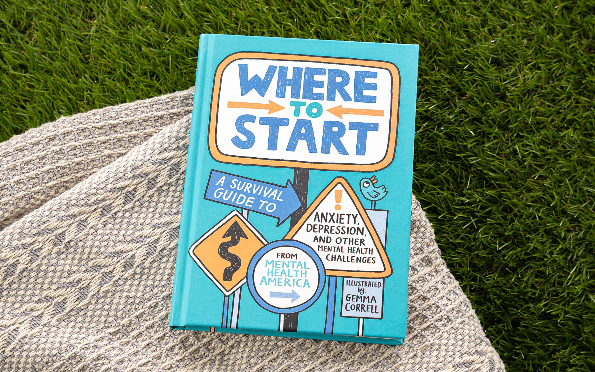 Where to Start book rests on blanket on top of grass