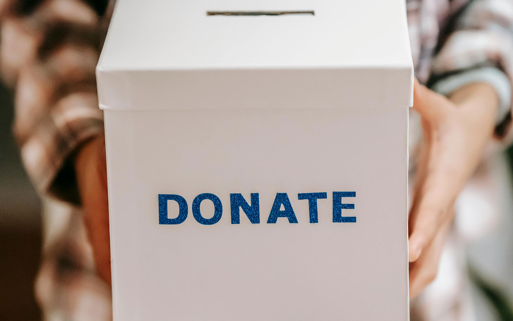 person holds box with DONATE on front of it