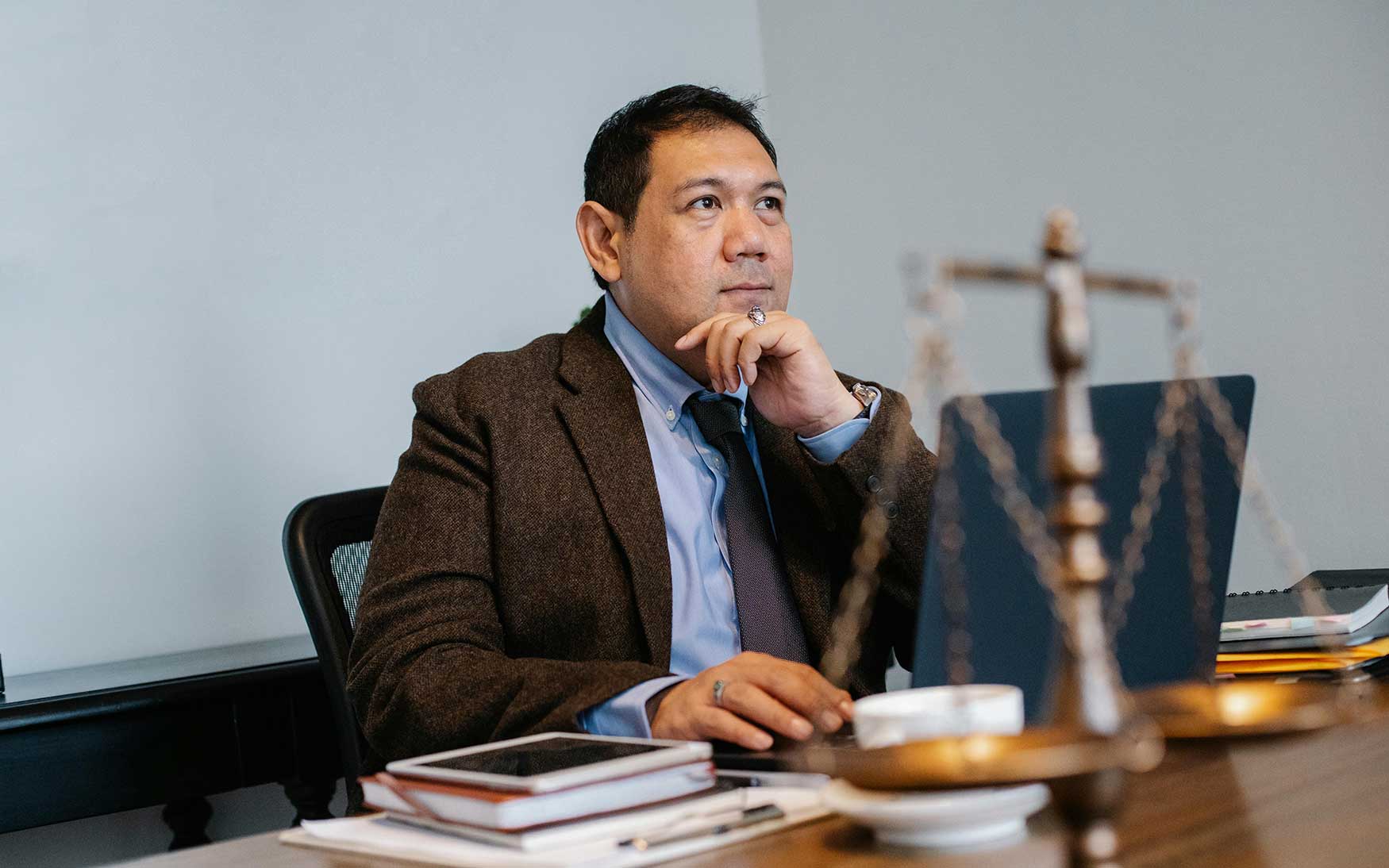 person sits at table with scales of justice in front of them