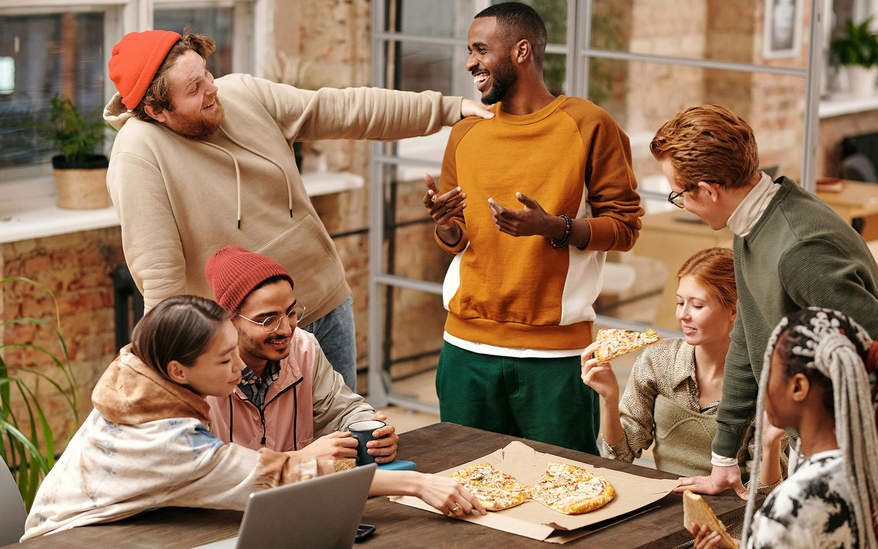 group of people talking and eating pizza