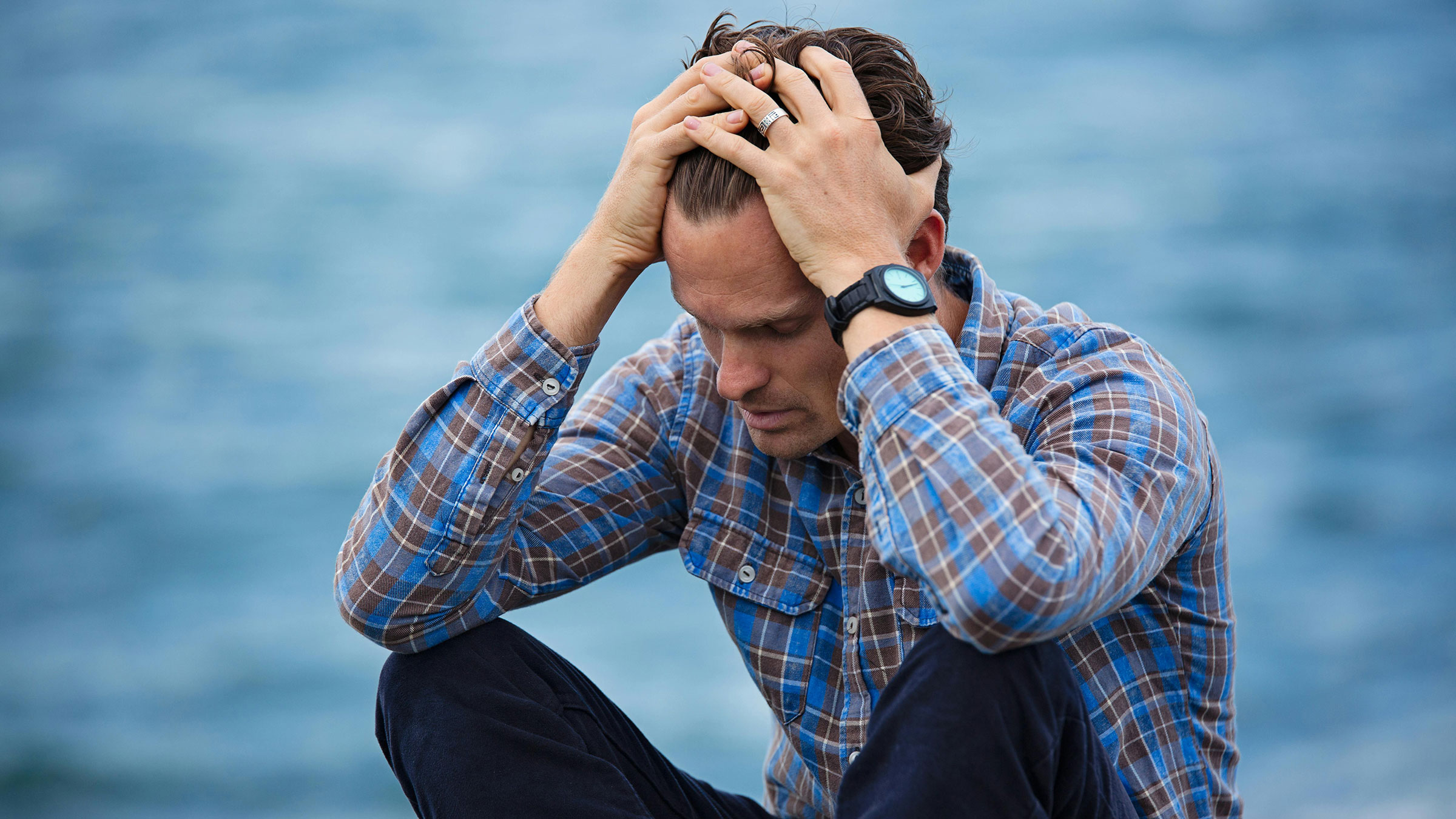 person sits with head in hands