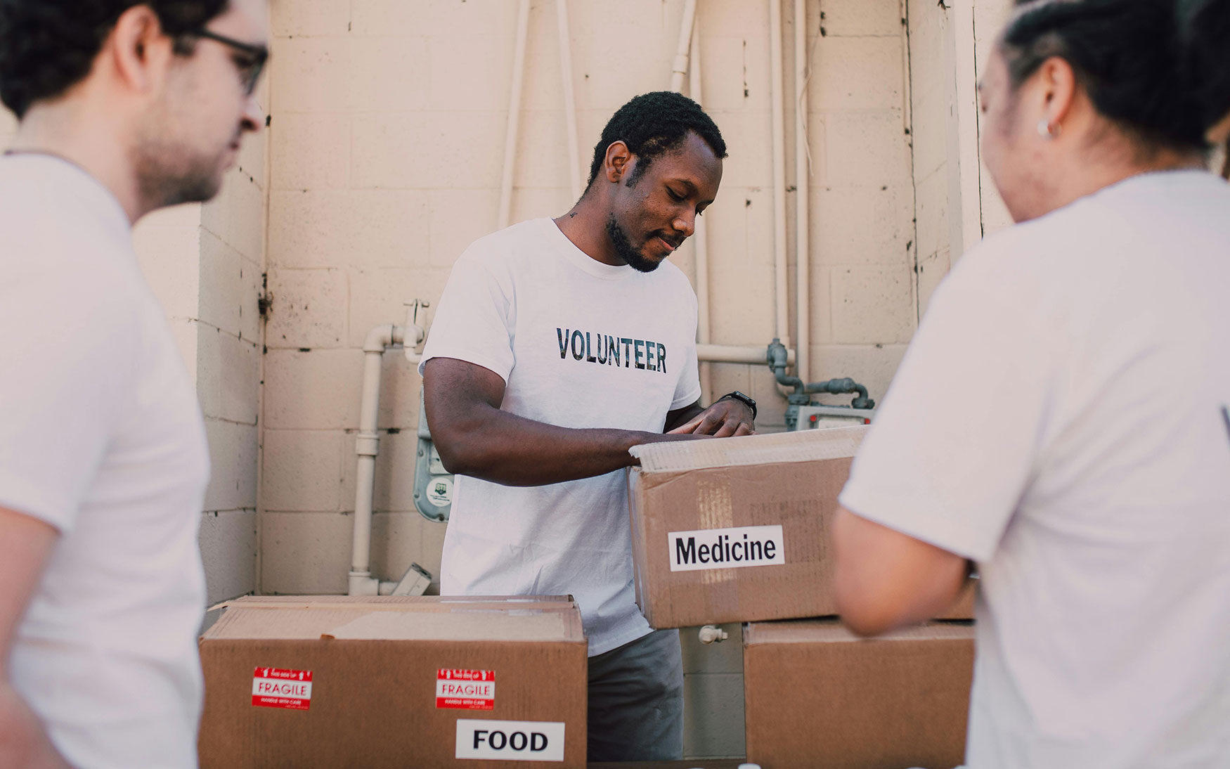 group of volunteers in white shirts handing out boxes