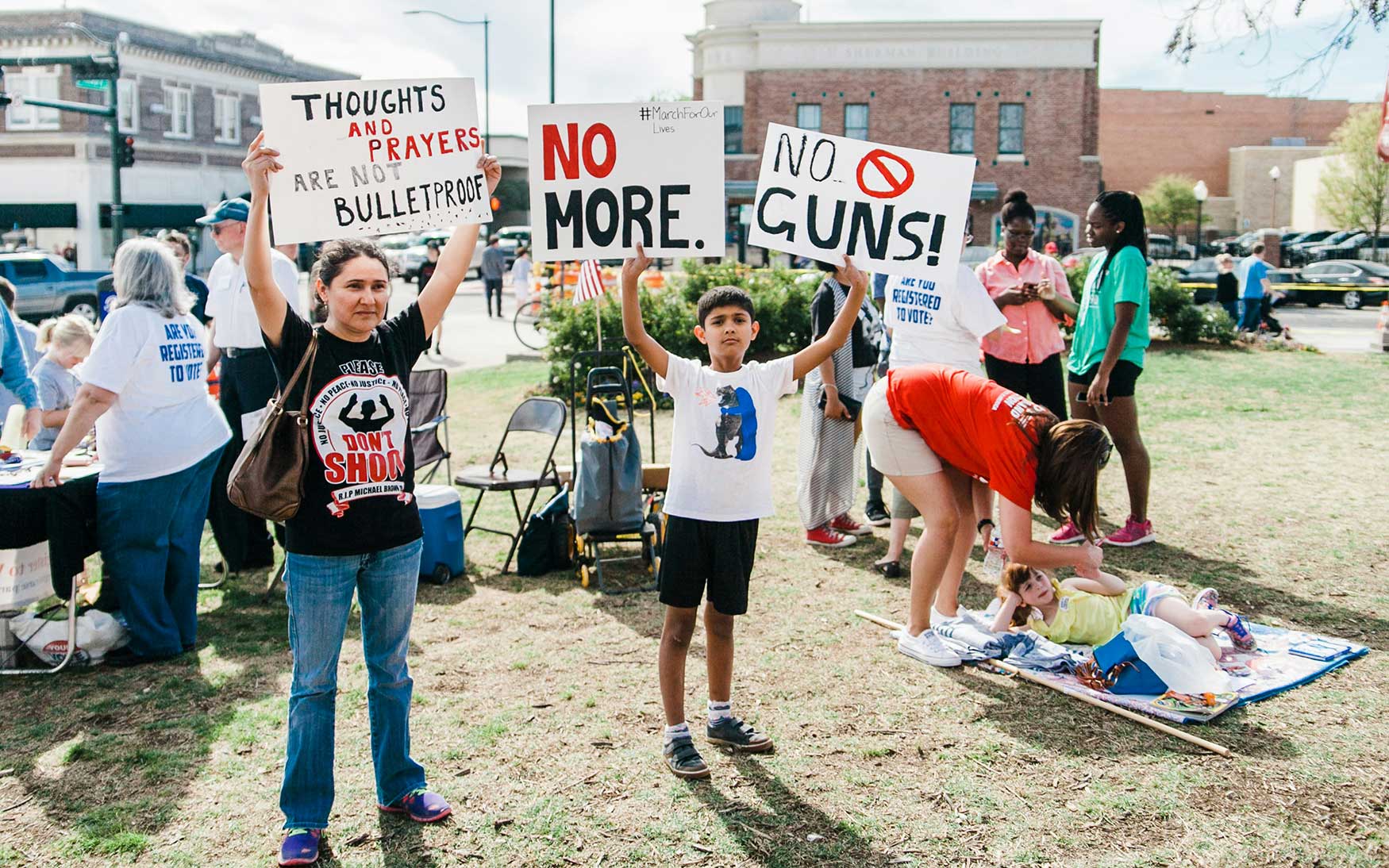 people stand holding signs with 