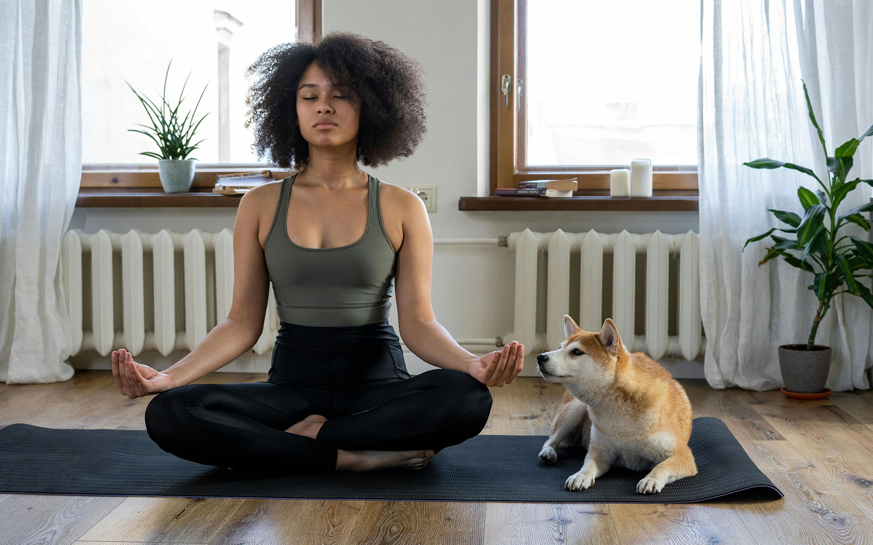 person sits on yoga mat and meditates