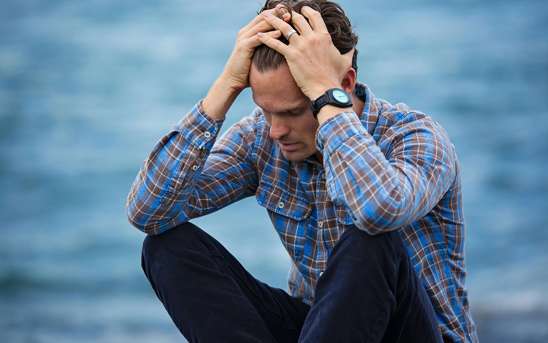 person sits with head in hands