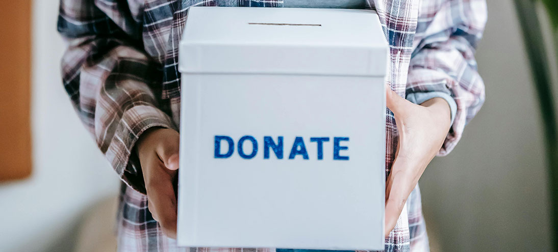 person holds a box with DONATE printed on it