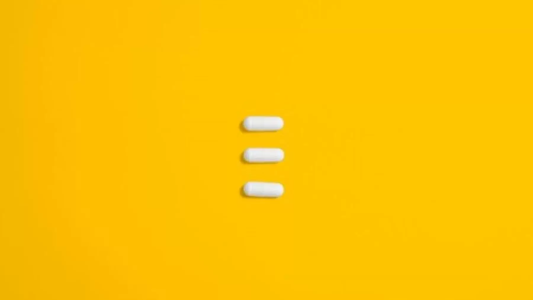 Three pills on a yellow background