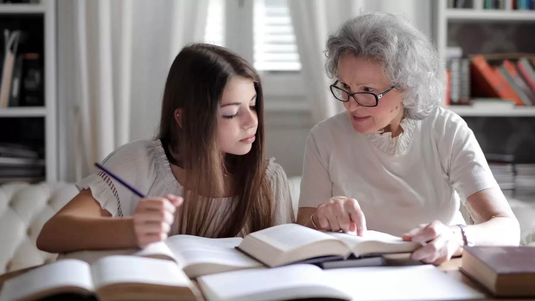 grandparent helps grandchild with homework