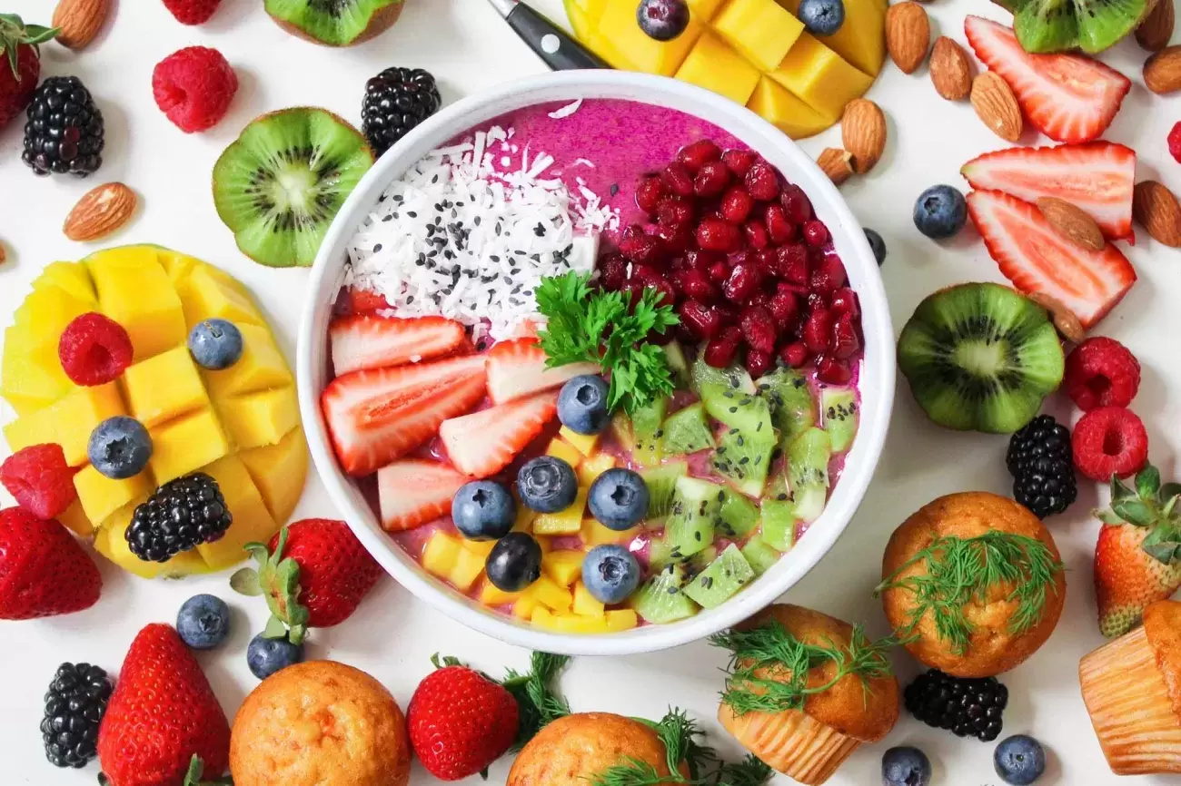 bowl with colorful foods both inside it and surrounding it