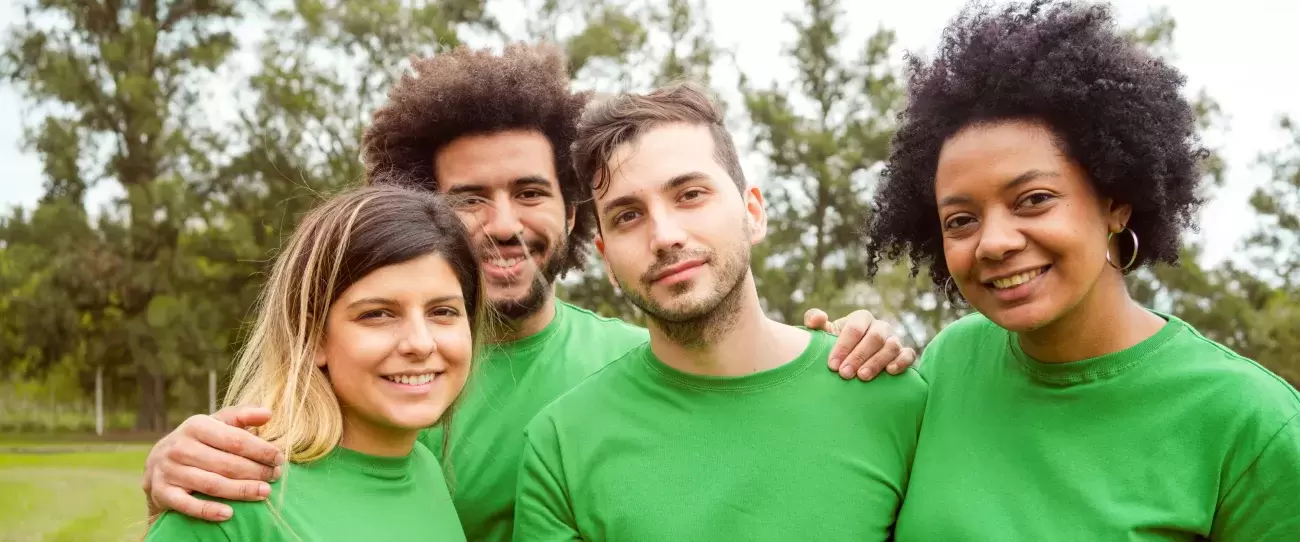 group of people wearing green pose together