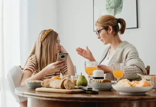 mom and kid talking over a table full of food