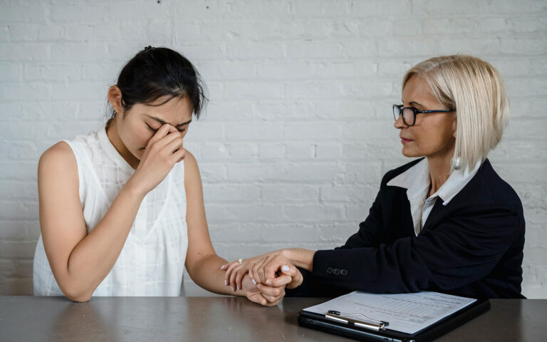 one person holds the hand of someone who is upset