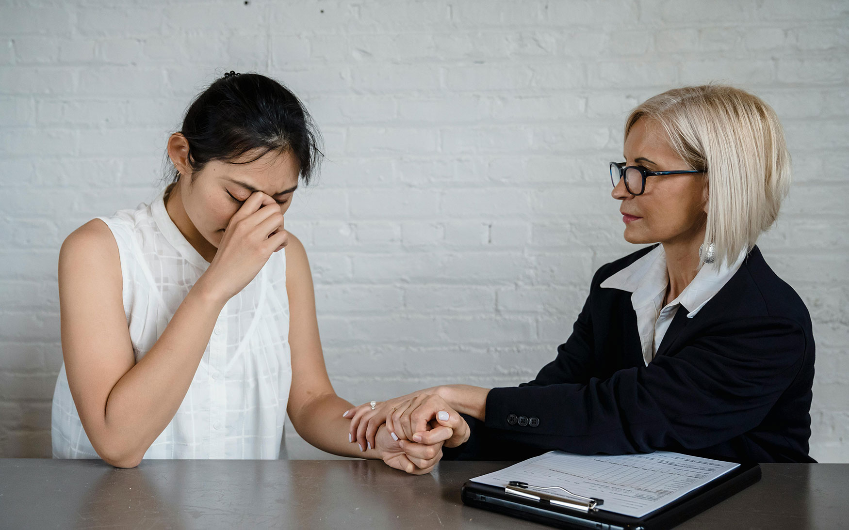one person holds the hand of someone who is upset
