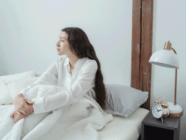 person sits up in bed