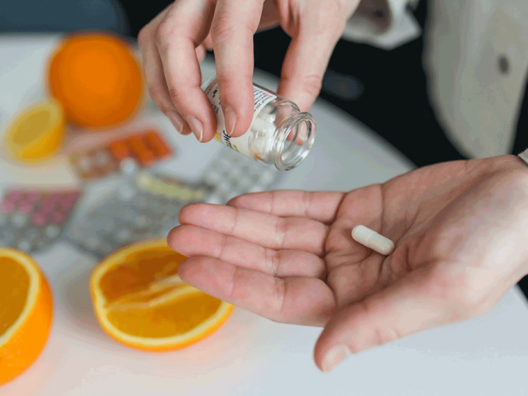 person pours pill into hand