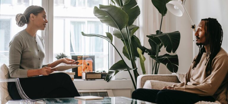 two people sit facing each other in a therapy session