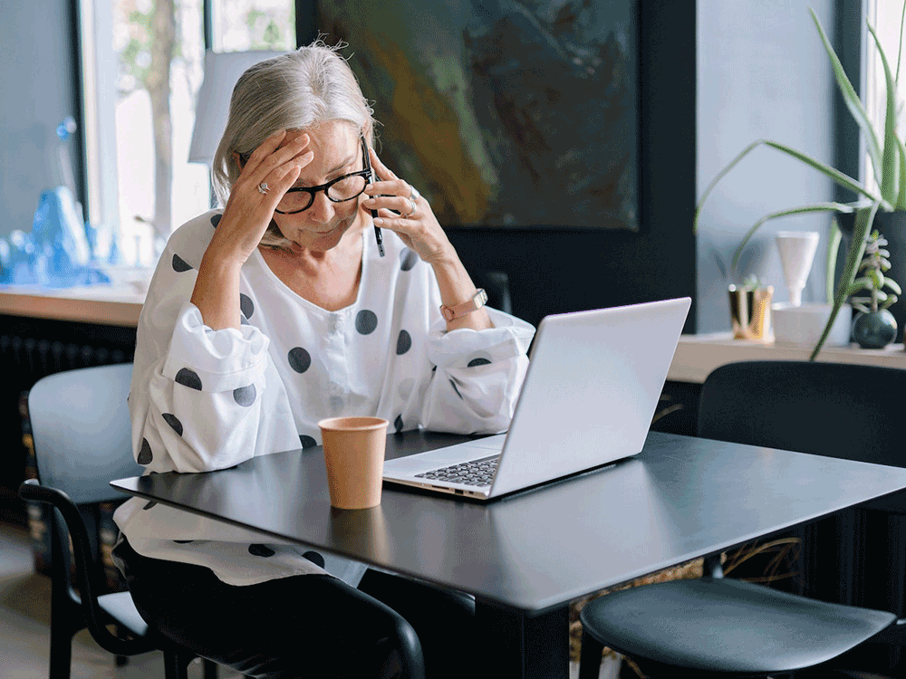 person looks at laptop and holds held in hands