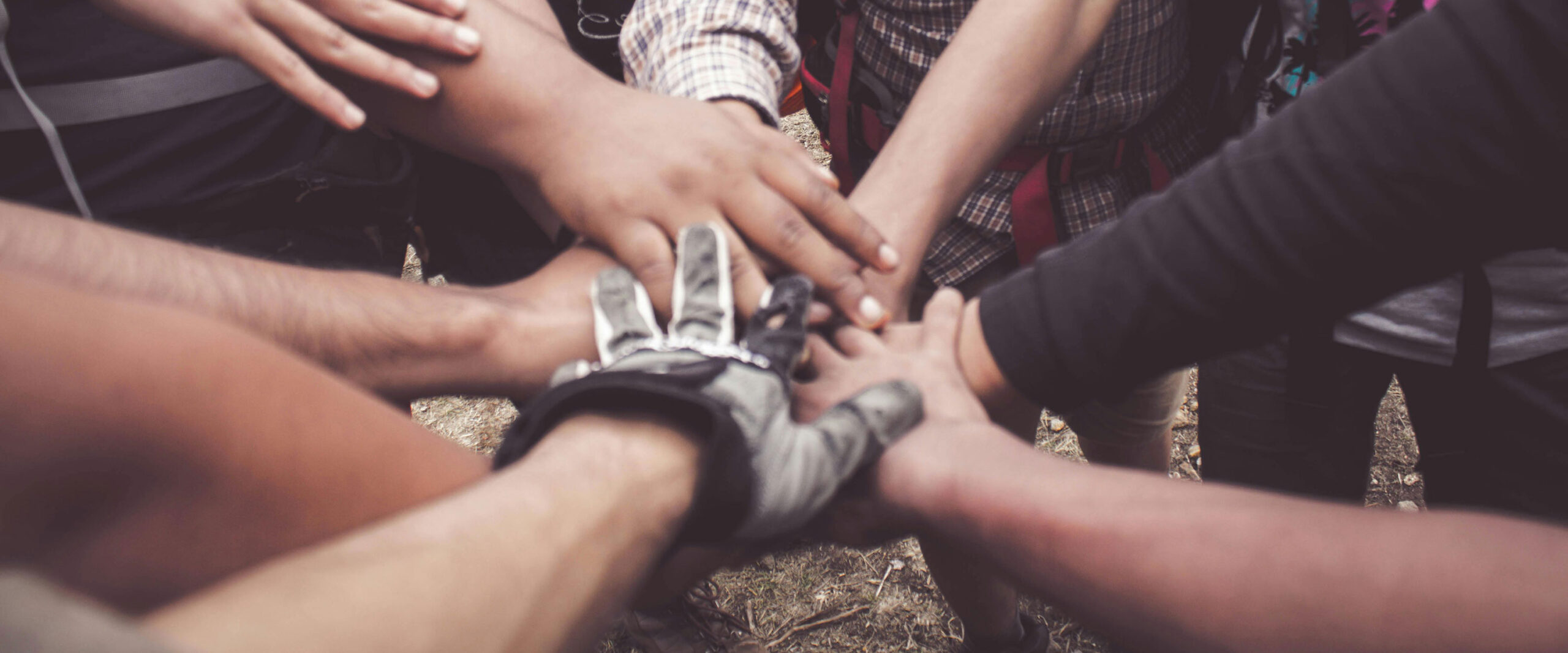 hands all thrown in a circle and stacked on top of each other