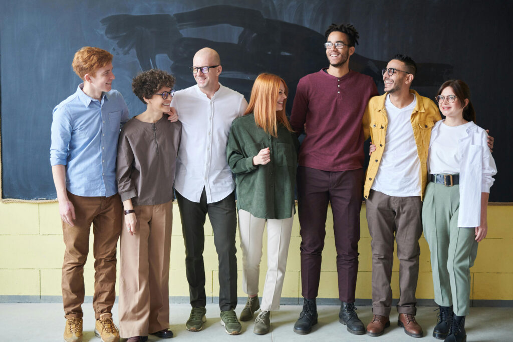 group of people stand in front of chalkboard with arms around each other