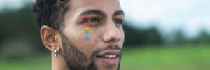 person with rainbow stripe painted on face