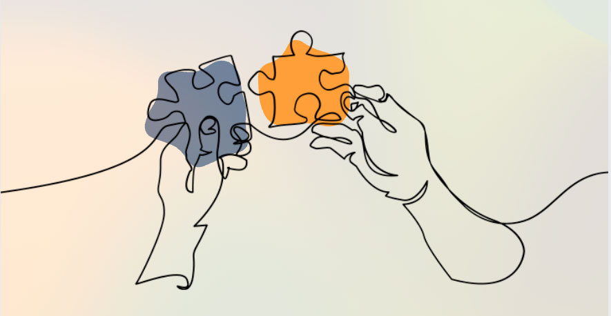 two hands, each holding a puzzle piece up to each other
