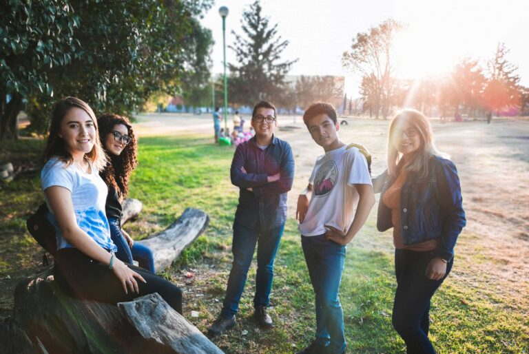 teenagers stand and sit in a park