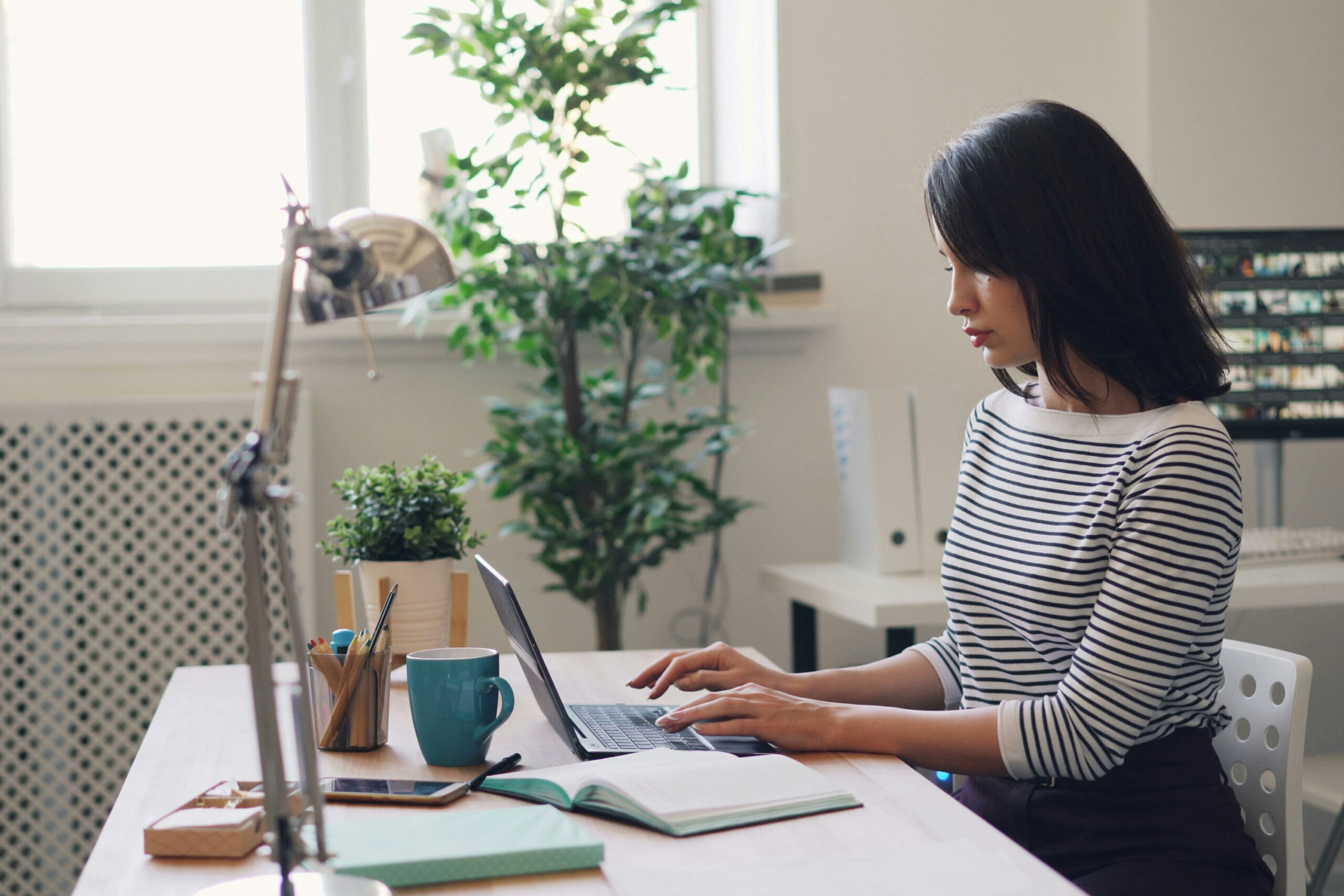 person sits at desk and types on laptop