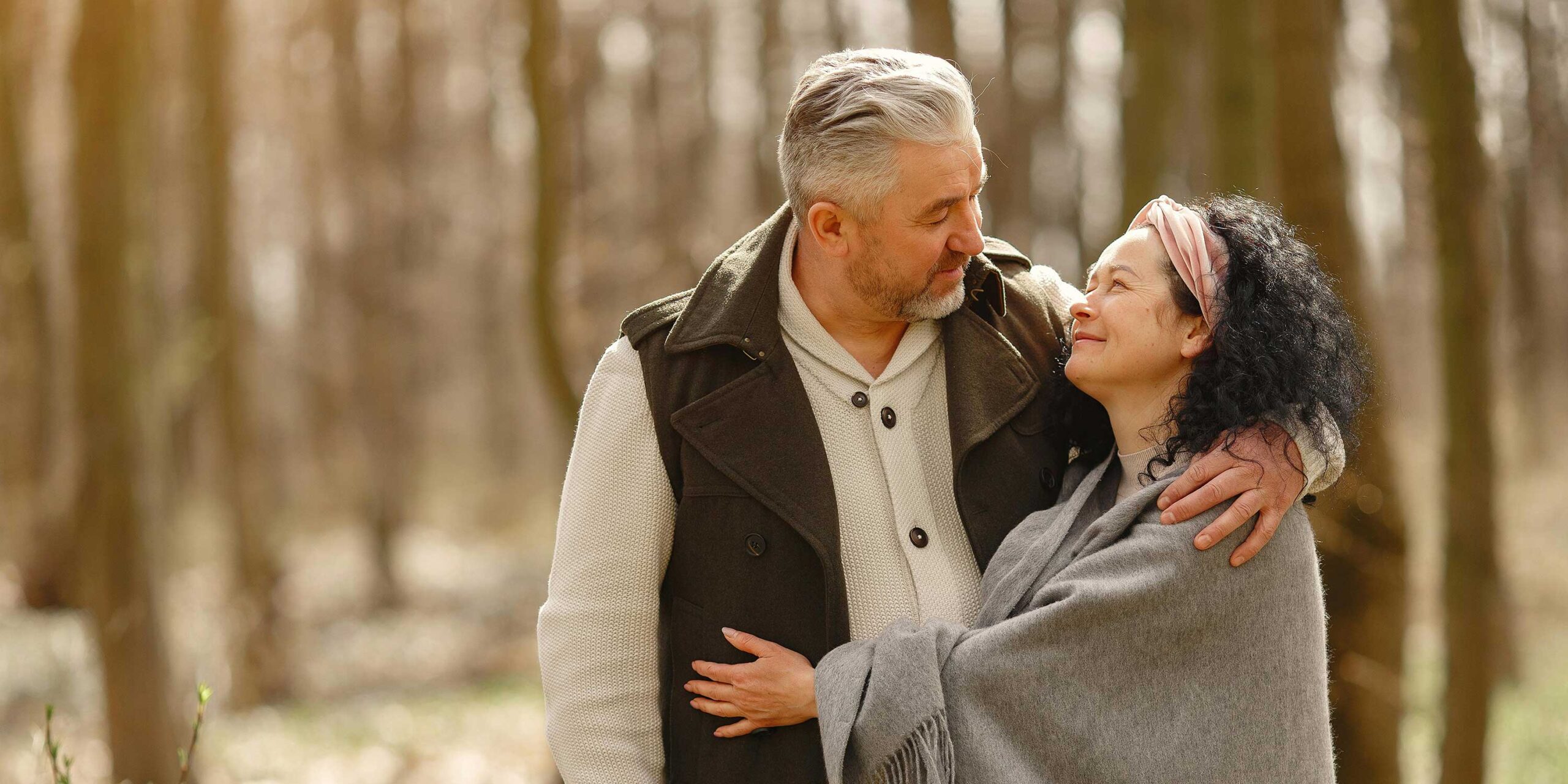 two people stand outside with arms around each other