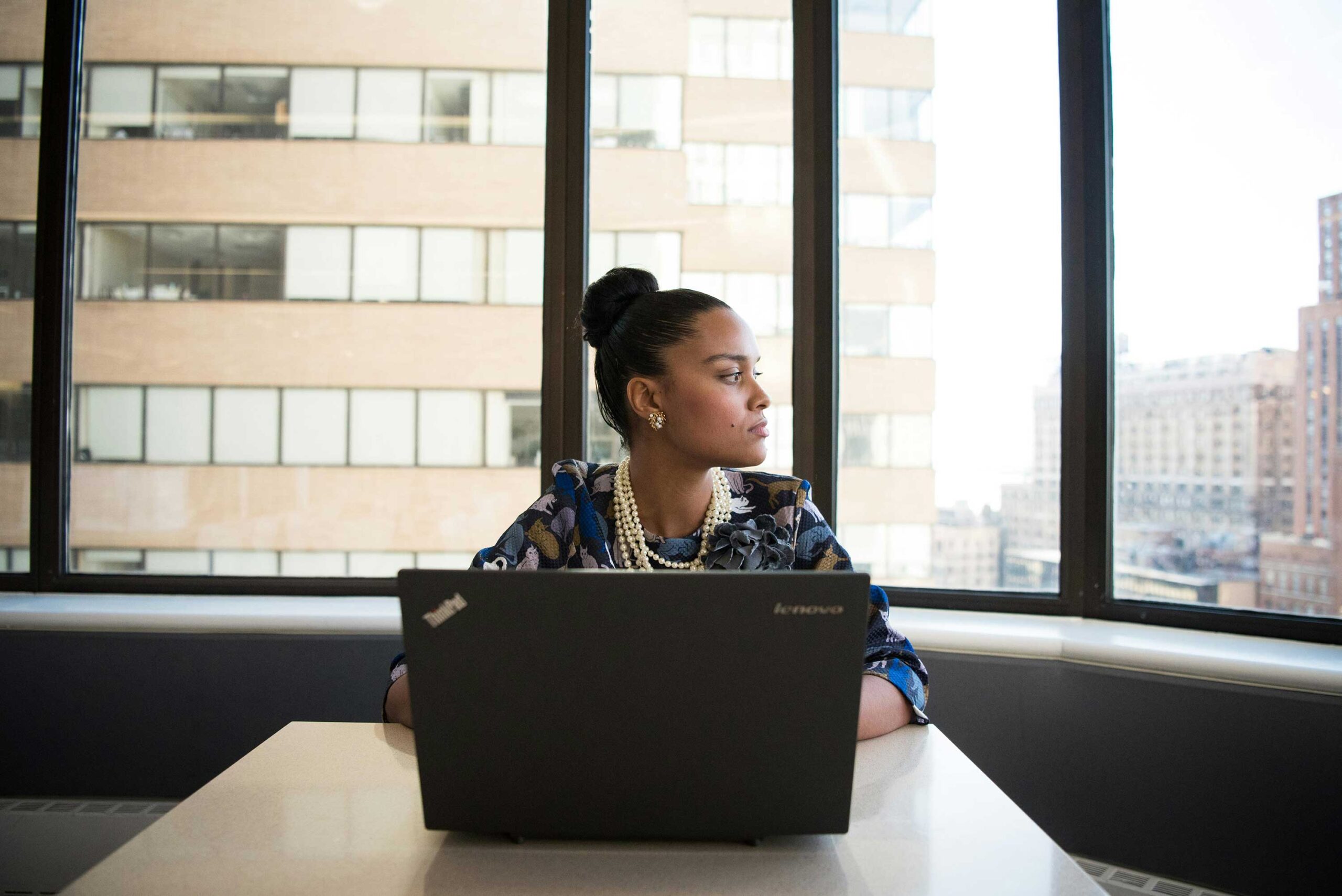 person sits at laptop looking off to side stressed