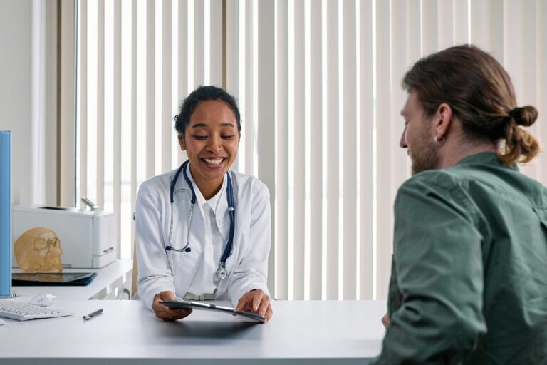 person talks to a medical professional sitting behind a desk